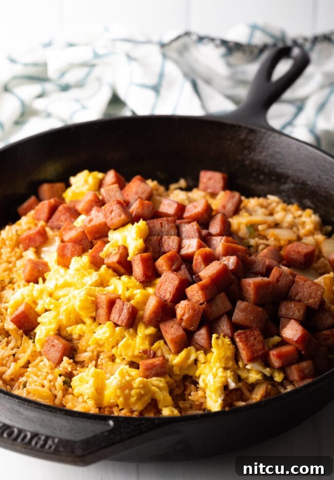 Tropical Kimchi Fried Rice 7 Skillet with rice, eggs, kimchi and cooked chopped spam.