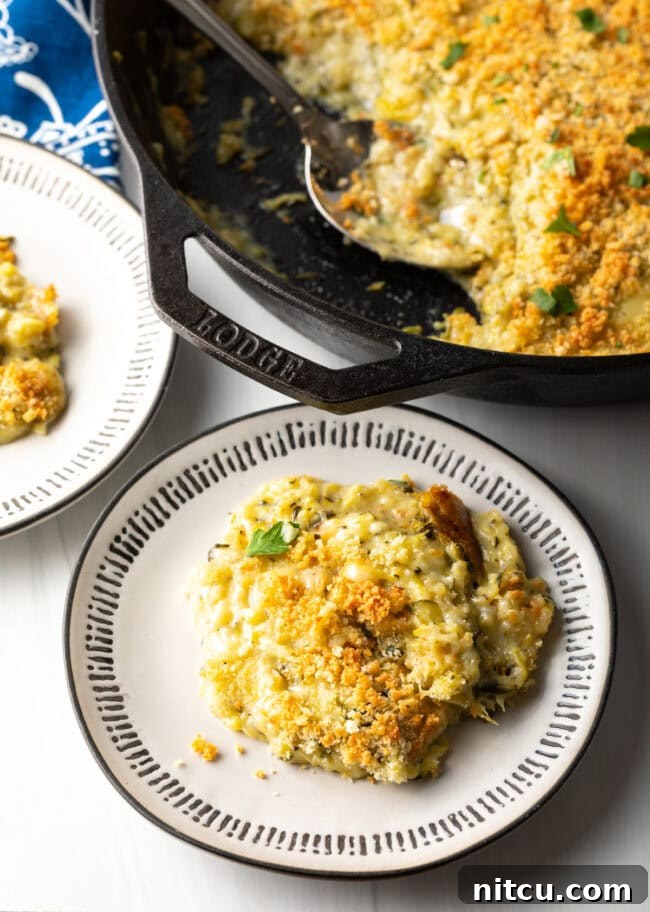 Golden Zucchini Gratin 10 Top down view servings on casserole with zucchini and cheese on a plate.