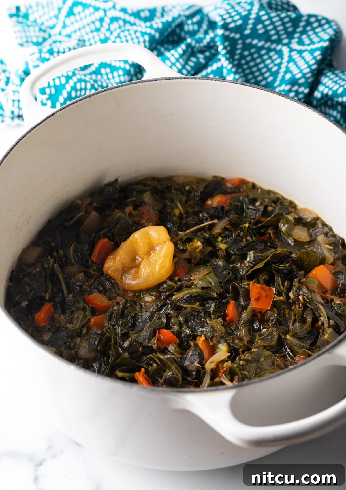 Vibrant Caribbean Callaloo 7 Top down view Jamaican stewed collard greens in a white pot. A top-down perspective of Jamaican stewed collard greens, showcasing the vibrant green and rich texture within a crisp white pot.