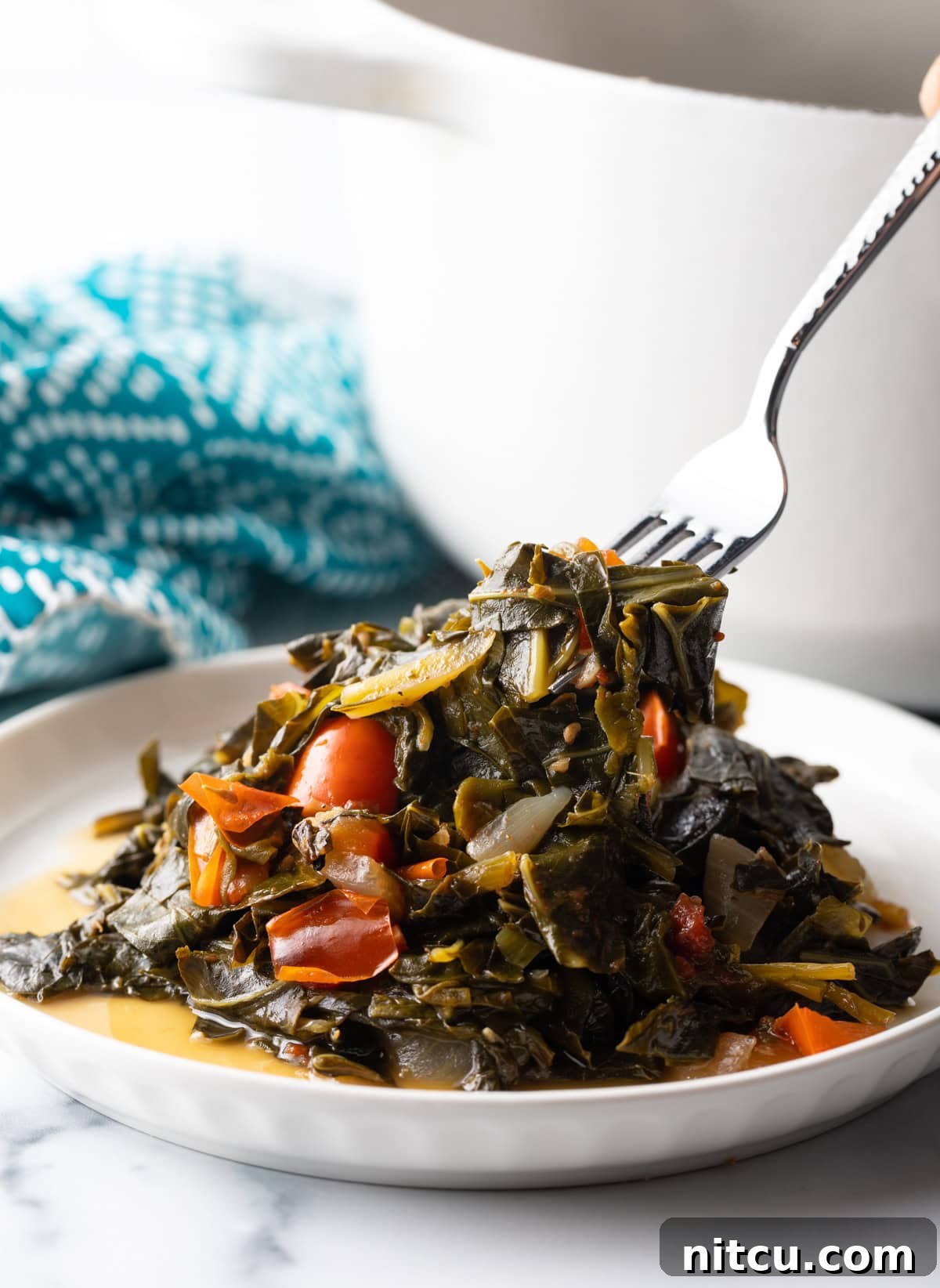 Vibrant Caribbean Callaloo 8 Fork digs into a plate filled with Callaloo greens. A fork digging into a plate piled high with tender Callaloo greens, ready to be enjoyed.