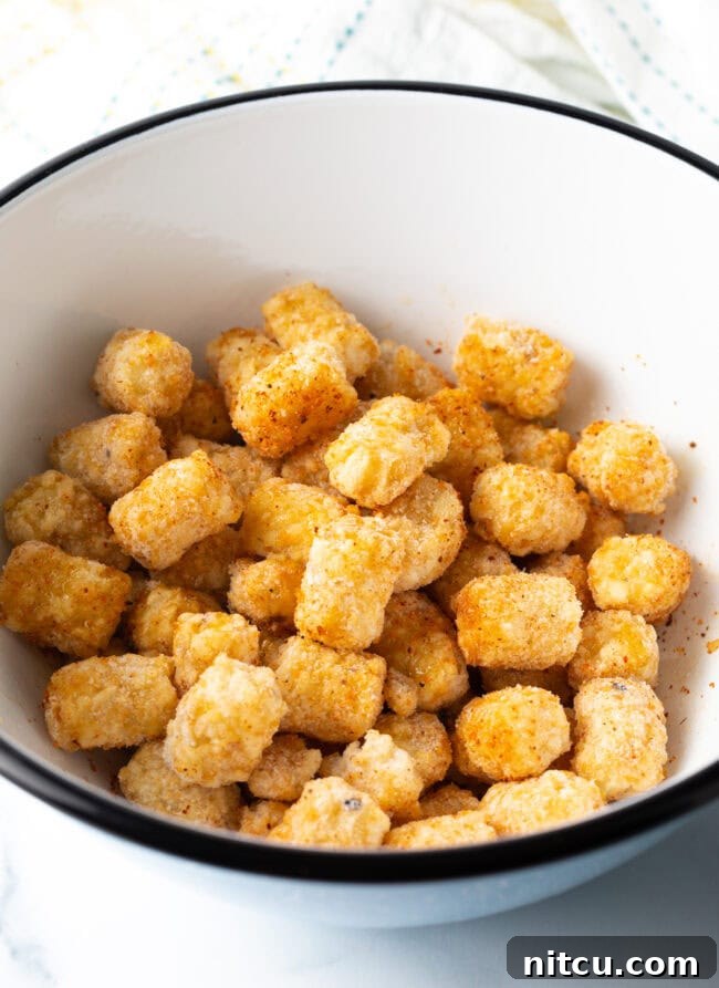 Frozen seasoned tater tots in a bowl.