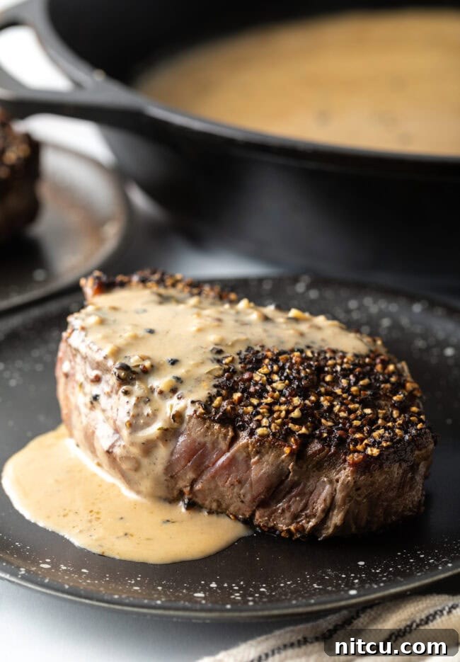 Peppercorn-Crusted Steak with Velvety Cognac Sauce 11 Close view Steak au Poivre with cognac cream sauce on a plate.