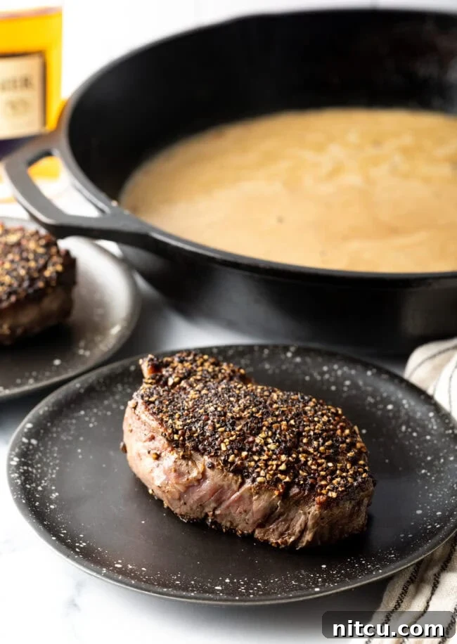 Peppercorn-Crusted Steak with Velvety Cognac Sauce 9 Peppercorn steak seared and resting on a plate.