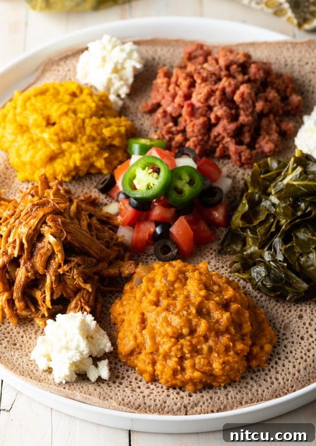Flavors of Ethiopia 10 A beautifully arranged Ethiopian shared platter, showcasing various vibrant dishes including lentil stews, greens, and injera bread, reflecting a communal dining experience.
