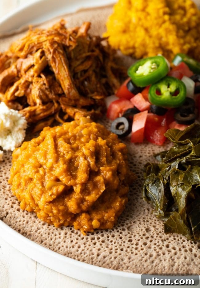 Flavors of Ethiopia 3 A traditional Ethiopian spread featuring Misir Wot, various stews, and vegetables served atop Injera bread, capturing the essence of a shared meal.