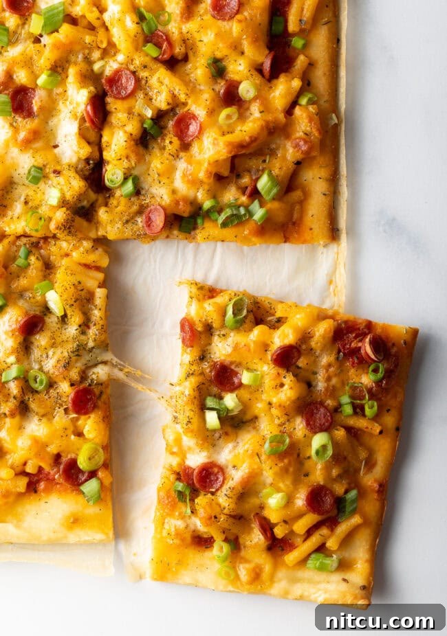 Cheesy Mac Pizza 11 Top down, square piece of pizza being removed.