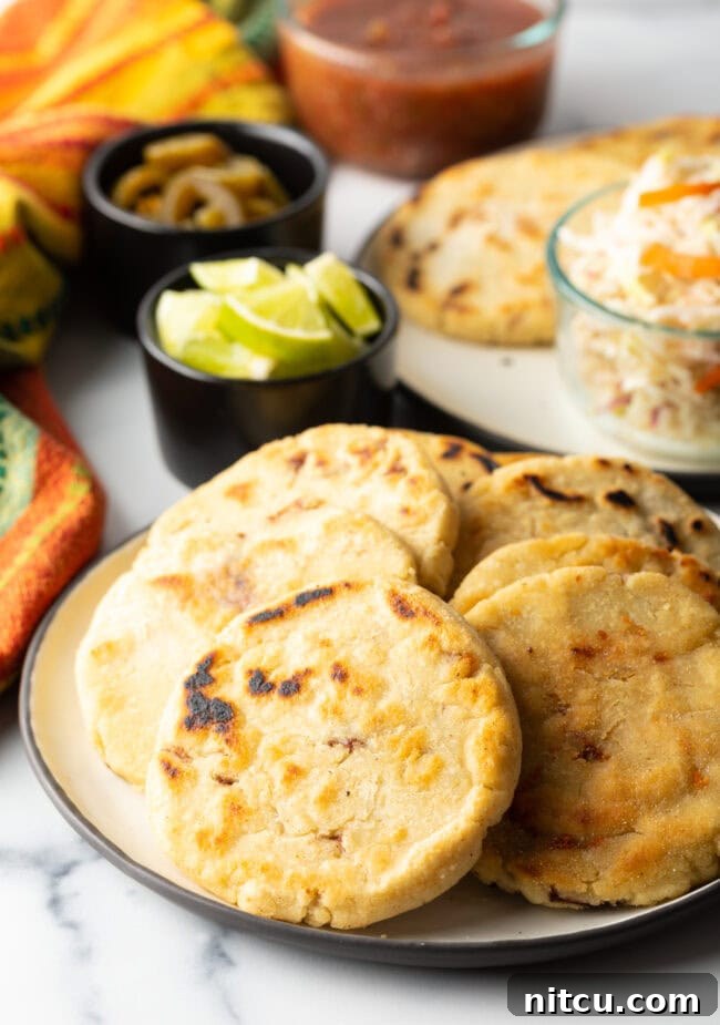 Homemade Pupusas 2 Thick corn pupusas recipe on a plate, garnished with curtido.