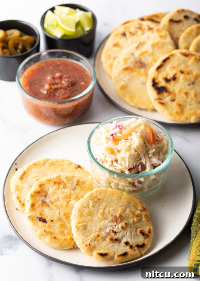Homemade Pupusas 19 Three pupusas on a plate with a small glass dish of curtido slaw.