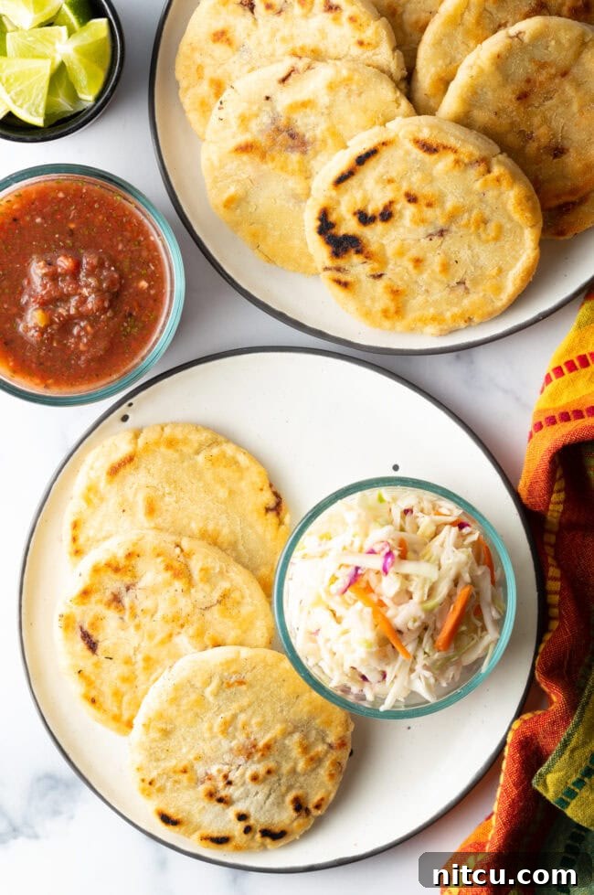 Homemade Pupusas 3 Top-down view of pupusas on a plate with fresh curtido slaw on the side.