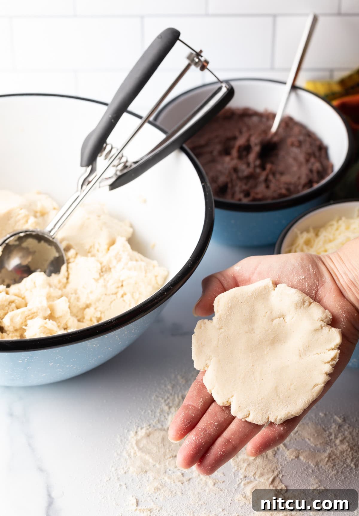 Homemade Pupusas 9 Hand holding a flattened disc of pupusa dough.