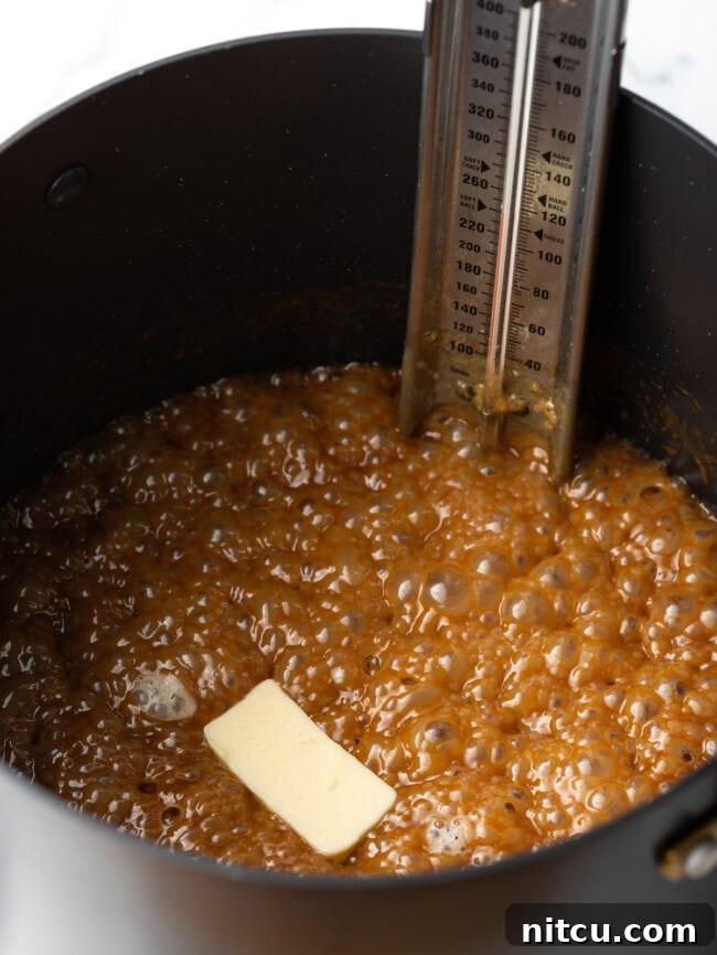 Creamy Maple Walnut Delight 7 Melted butter has just been added to the hot maple syrup and cream mixture in the saucepot, glistening on the surface.