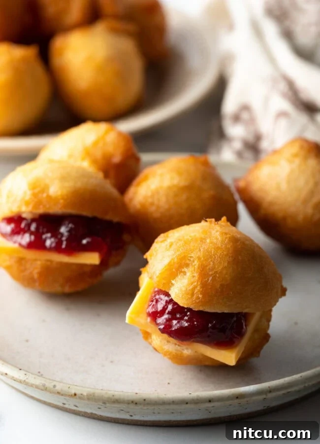 Decadent Cake Creation 5 An array of mini fried dough bites, some filled with cheese and jam, others with minced meat.