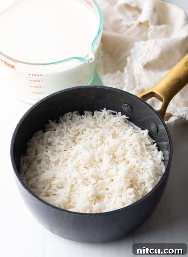 Golden Baked Rice Pudding 5 Small saucepan with perfectly cooked white rice, ready to be incorporated into the custard mixture.