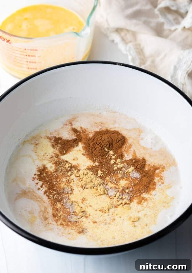 Golden Baked Rice Pudding 6 Large mixing bowl filled with half and half, beaten eggs, sugar, vanilla, and various spices, all waiting to be whisked together.