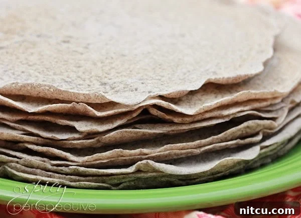 Cooked injera bread stacked on a plate. 