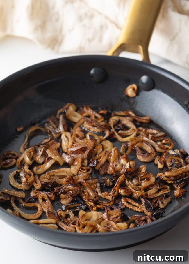 Gooey Baked Camembert Delight 8 Sauteeing sliced shallots in a skillet until browned.