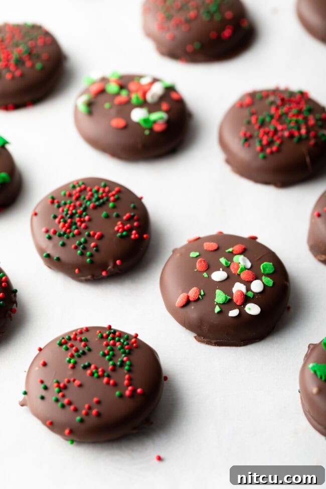 Refreshing Homemade Peppermint Delights 11 Close view chocolate peppermint candies topped with sprinkles, lines of treats on parchment paper.