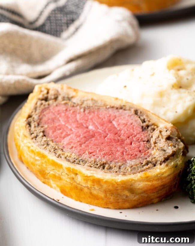 Close view beef tenderloin wrapped in mushroom pate and puff pastry.
