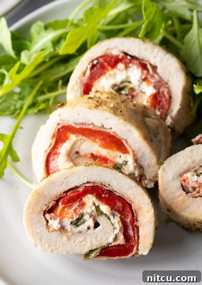 Savory Stuffed Chicken Rolls 2 Sliced chicken roulade pieces on a plate with close view of cut section, showcasing the vibrant filling.