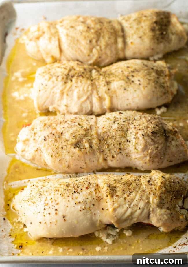 Savory Stuffed Chicken Rolls 11 Baked roulade, cooked to perfection and still wrapped on a baking sheet, showcasing golden-brown exterior.