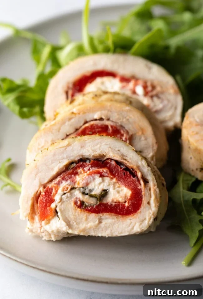 Savory Stuffed Chicken Rolls 15 Close view pieces of chicken roulade on a plate, showcasing texture and rich filling.