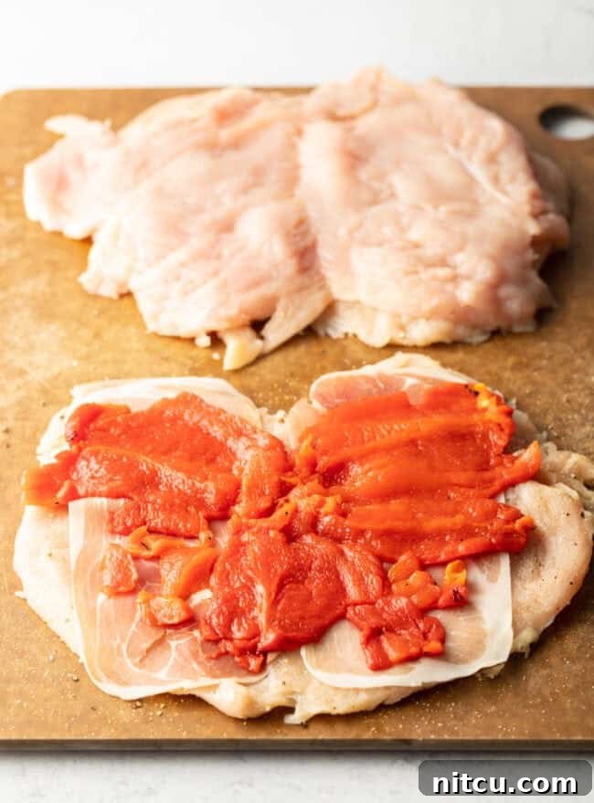 Savory Stuffed Chicken Rolls 7 Slices of roasted red pepper laid flat on open slices of raw chicken.