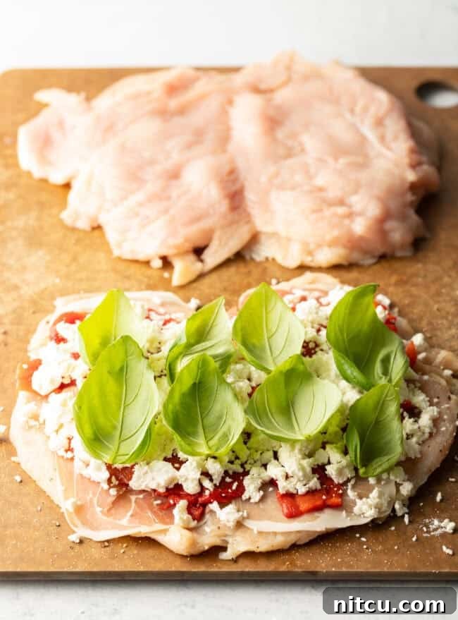 Savory Stuffed Chicken Rolls 8 Butterflied chicken breasts split open, topped with prosciutto, red peppers, crumbled goat cheese and fresh baby basil leaves, ready to be rolled.