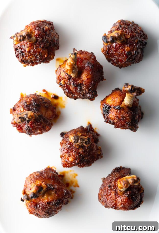 Irresistible Sweet Heat Chicken Lollipops 3 Top down 8 drumettes on a white serving platter.