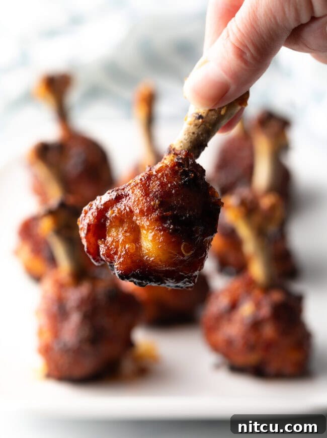 Irresistible Sweet Heat Chicken Lollipops 4 Hand holding chicken lollipop to camera.
