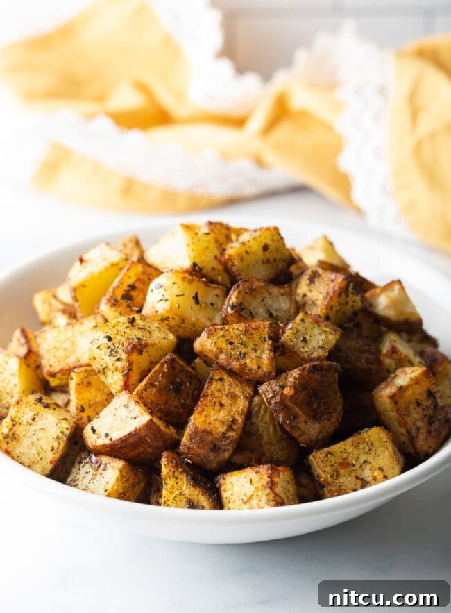Russet Potatoes Ultimate Recipe and Cooking Tips 2 Russet Potato Recipe and Tips -Close view cubed fried potatoes in a white bowl.