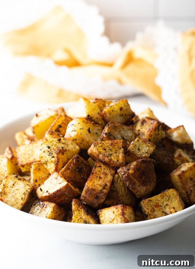 Russet Potatoes Ultimate Recipe and Cooking Tips 14 Cubes of roasted seasoned russet potato in a white bowl.