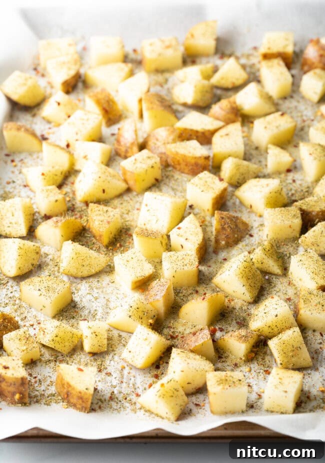 Russet Potatoes Ultimate Recipe and Cooking Tips 7 Raw cubes seasoned on parchment.