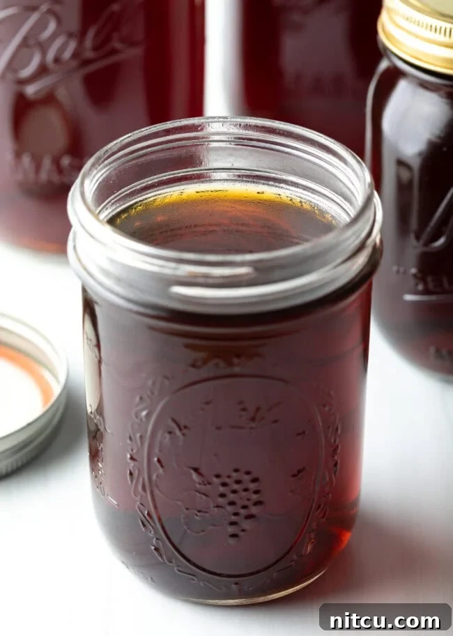 Golden Beef Essence 2 Close up view of beef consomme in a glass jar.