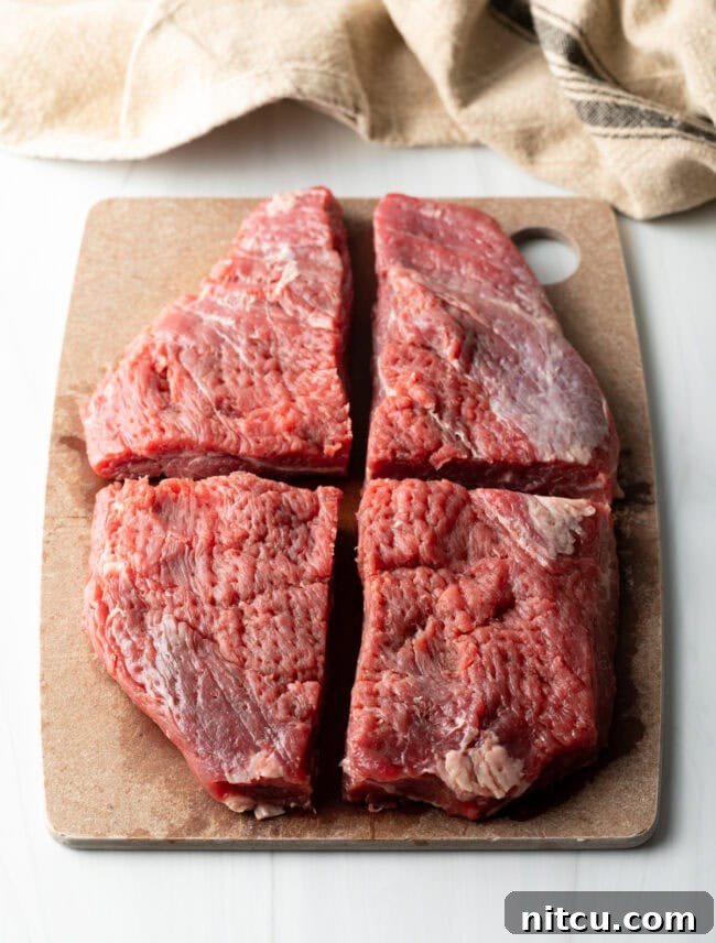Authentic Street Style Beef Shawarma 6 Large piece of flank steak cut into 4 quarters, on a cutting board.