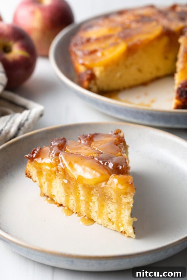 Effortless Apple Caramel Flip Cake 10 Slice of apple upside down cake on a white plate with whiskey sauce on top.
