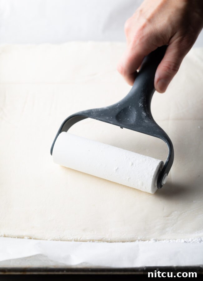 Spudnut Delights 9 Hand with roller flattening out sheet of mashed potato mixture.