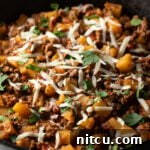 Tuscan Beef & Potato Skillet 12 Ground beef and potatoes, topped with shredded parmesan cheese in a skillet.