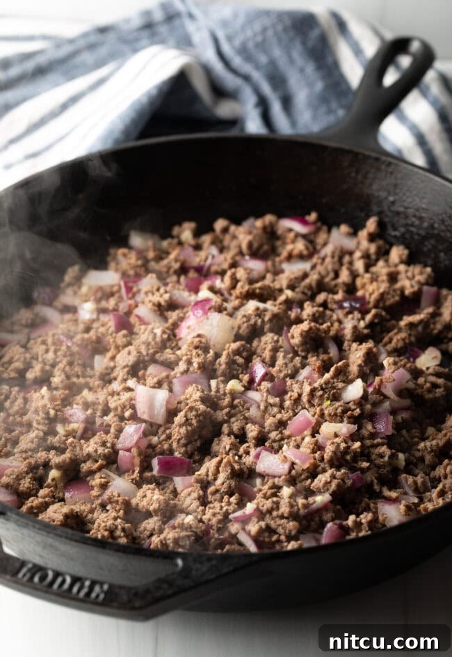 Tuscan Beef & Potato Skillet 5 Meat and onions cooking in a skillet.
