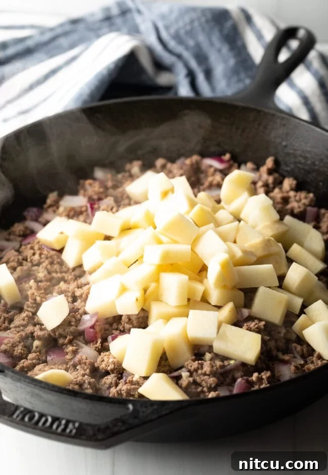 Tuscan Beef & Potato Skillet 6 Adding chopped potatoes to the skillet.