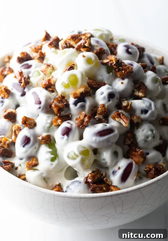 Refreshing Creamy Grape Salad 2 Close top down view salad made with green and red grapes, cream cheese, and pecans.