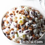 Refreshing Creamy Grape Salad 13 Grape salad in a white bowl.