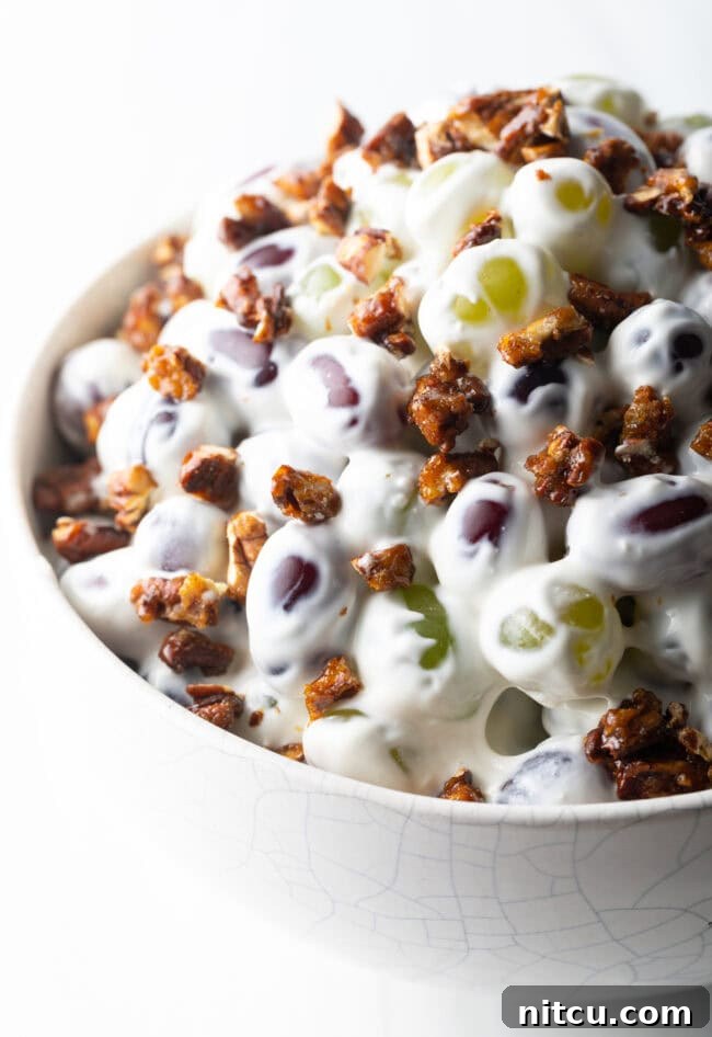 Refreshing Creamy Grape Salad 9 Close top down view salad made with green and red grapes, cream cheese, and pecans.