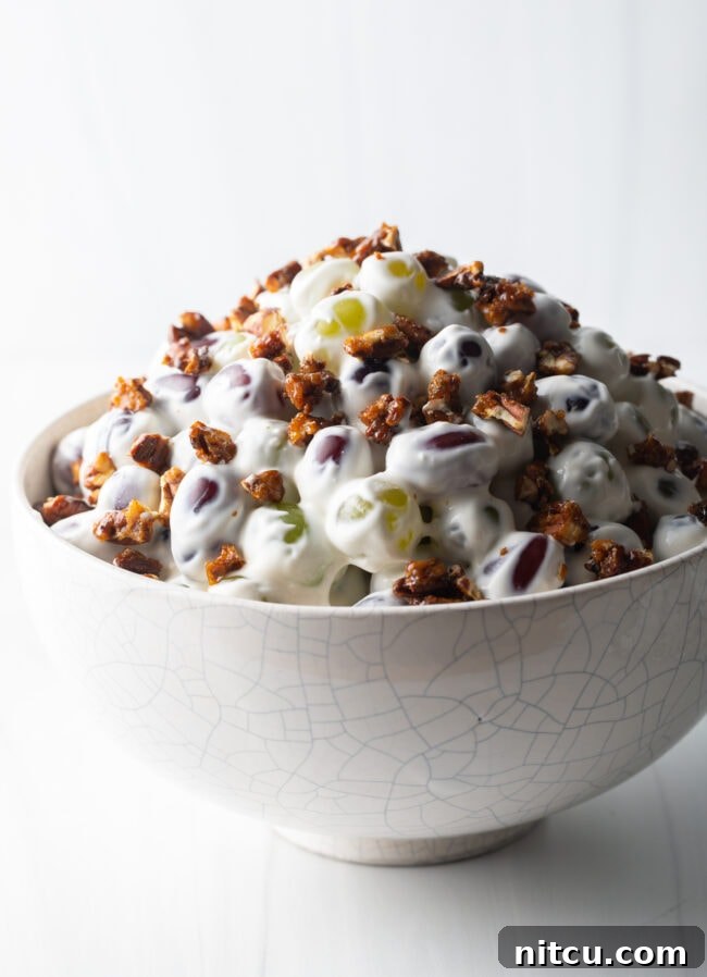 Refreshing Creamy Grape Salad 10 Side view of creamy salad with grapes in a white bowl.