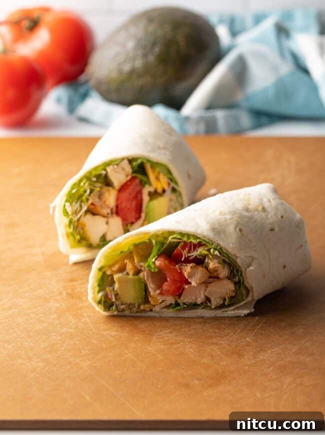 Your New Favorite Chicken Wrap 11 Two halves of a grilled chicken wrap lying one in front of the other.