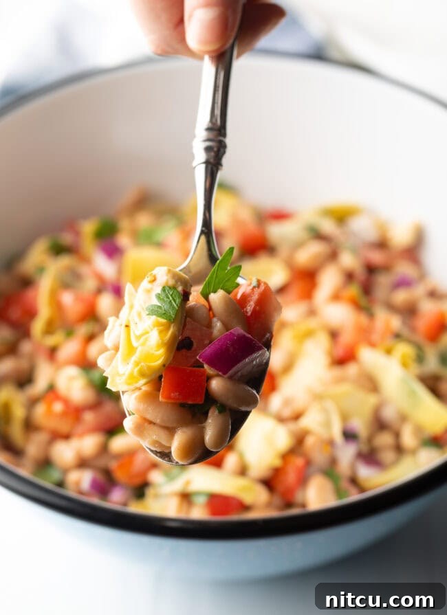 Metal spoon showing spoonful of the salad to camera.
