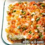 Fiesta Bean Stack 12 View of glass dish with portion missing, showing all 5 layers of the Mexican bean dip.