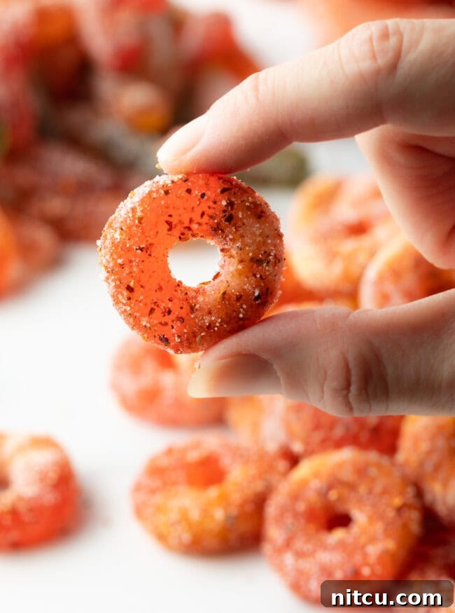 Spicy Chamoy Mexican Candies 12 Hand holding a perfectly seasoned Mexican Chamoy Candy (dulces enchilados) ring, ready to be enjoyed.