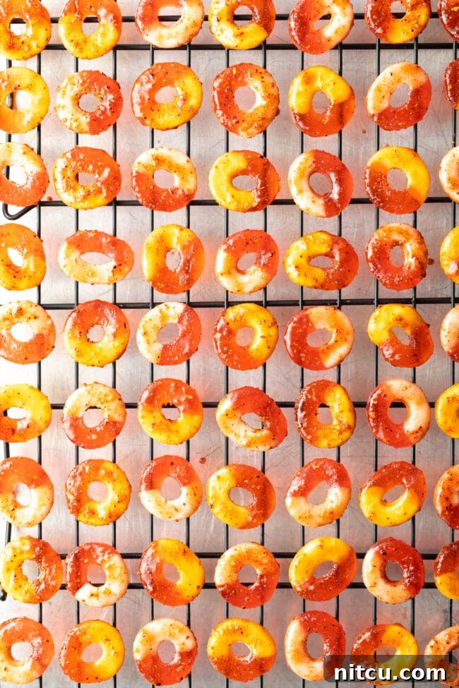 Spicy Chamoy Mexican Candies 8 Chamoy and Tajin coated gummy candy rings laid out in neat rows on metal drying racks.