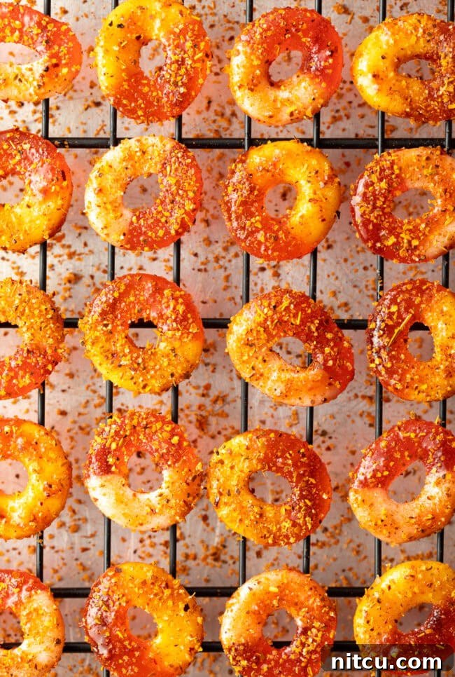 Spicy Chamoy Mexican Candies 9 Close-up of Chamoy and Tajin coated gummy candy rings drying on metal racks.