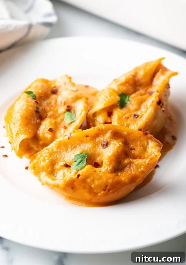 Ocean's Bounty Stuffed Shells 2 Serving of cheesy seafood pasta on a white plate.